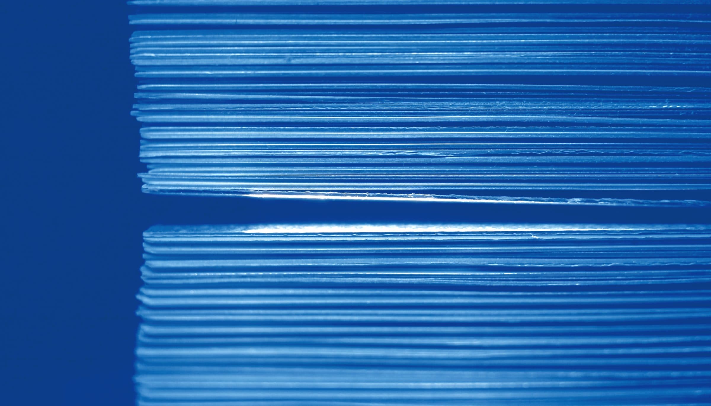 Many parallel metal layers with a single channel cut cleanly through them.