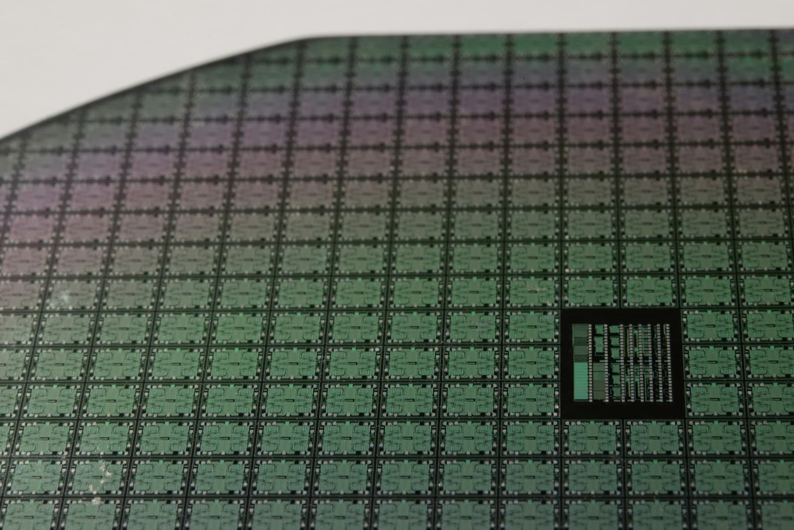 Macro of a dark wafer surface, its square dies laid out in a fine grid.